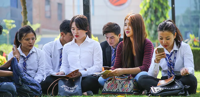International students sitting outdoors at LPU campus